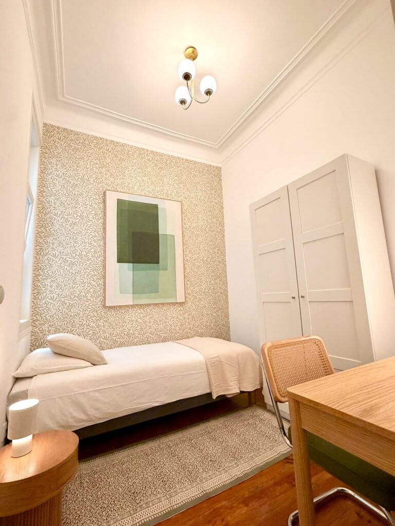 Single room with leaf wallpaper, artwork, wardrobe and desk at LX1 Coliving
