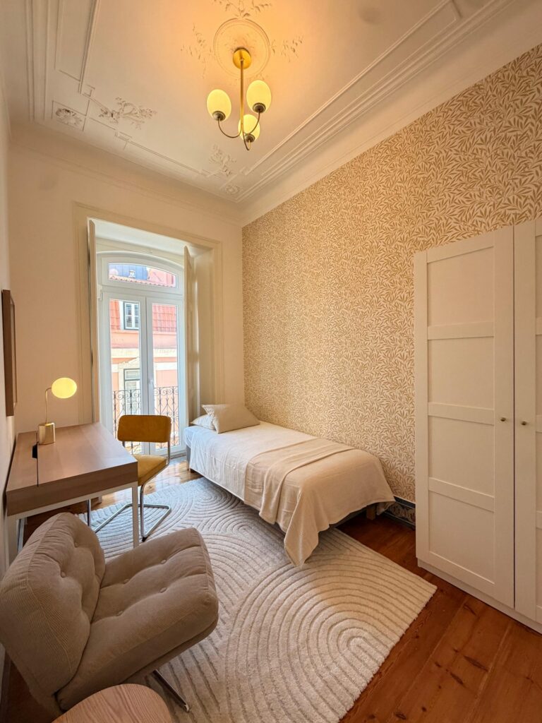 Furnished single room with wallpaper, desk and wardrobe at LX1 Coliving